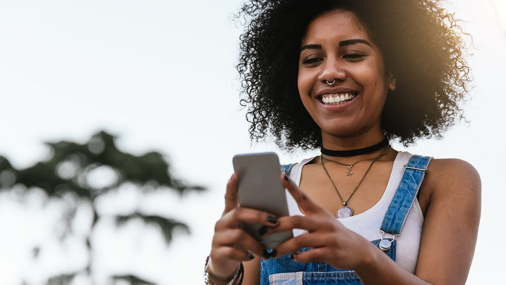 Cervical cancer is one of the leading causes of mortality among women. How can new technology affect Cervical cancer rates? - woman holding a phone smiling