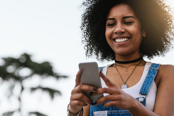 Cervical cancer is one of the leading causes of mortality among women. How can new technology affect Cervical cancer rates? - woman holding a phone smiling