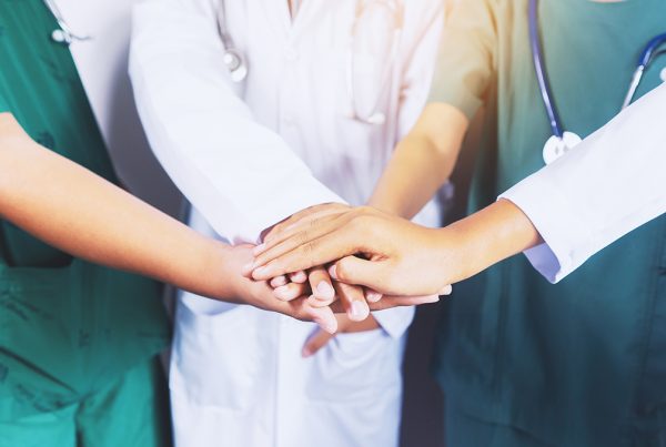 Addressing the Current Healthcare Staffing Crisis - health care workers holding hands